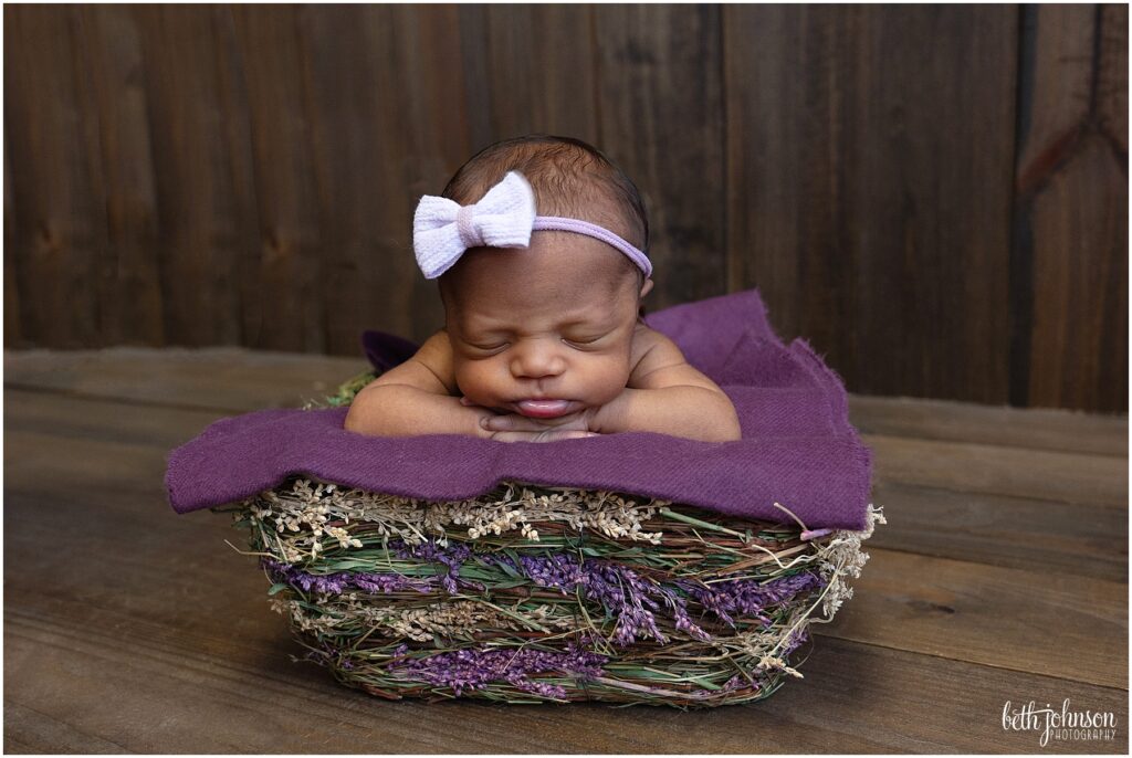 newborn baby girl in lavender crate