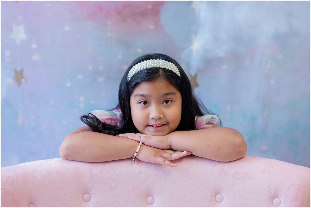 young girl on pink couch photography studio