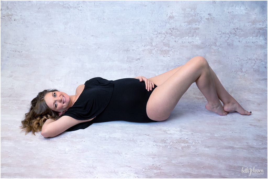 maternity black bodysuit lying down