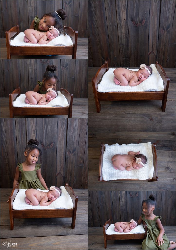 baby girl and big sister on wooden backdrop
