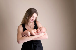 mom in black dress holding newborn