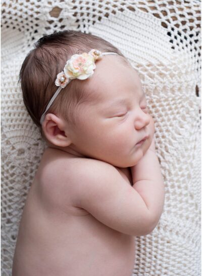 side lying newborn on lace crochet doily