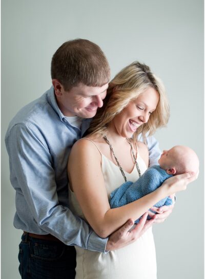 parents smiling at newborn baby