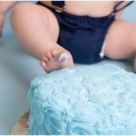 baby putting foot into cake smash