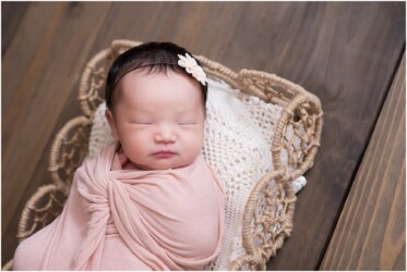 newborn girl in pink wrap in prop