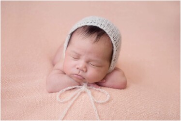 baby in bonnet tied with bow