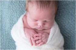 swaddled baby with hands out