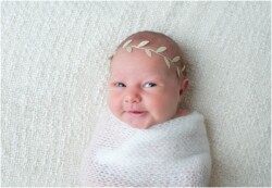 smiling newborn with gold leaf headband
