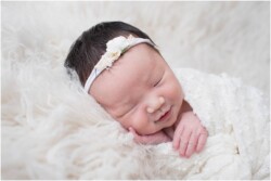 smiling baby girl in white swaddle wrap