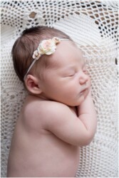 side lying newborn on lace crochet doily