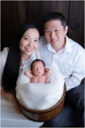 parents holding newborn baby in prop