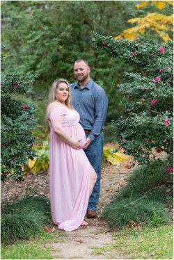 maternity photos parents in front of flower arch