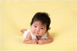 baby girl on yellow backdrop
