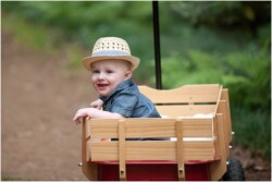 baby boy in hat and red radio flyer wagon