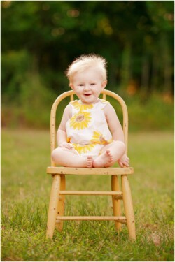 blonde baby with lots of hair wearing sunflowers
