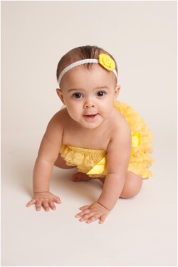 baby in yellow romper crawling