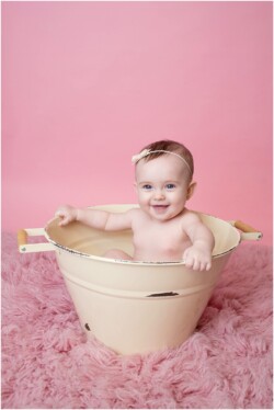 baby girl in ivory bucket on pink flokati
