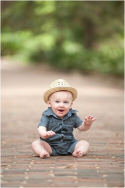 baby in hat sitting outside on bricks