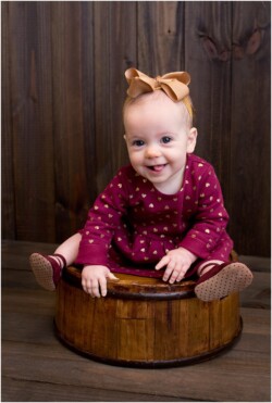 baby girl sitting on round bucket