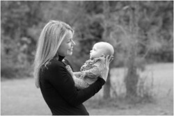 mom looking at new baby backlit outdoors black and white