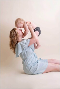 mom holding baby above head in studio