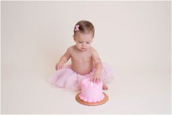 dainty baby girl eating birthday cake