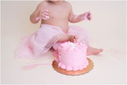 baby putting her foot in cake