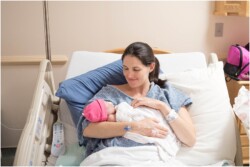 smiling mom and newborn daughter