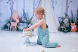baby kneeling forward reaching cake