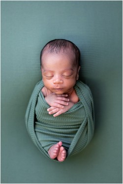 newborn boy on olive green blanket