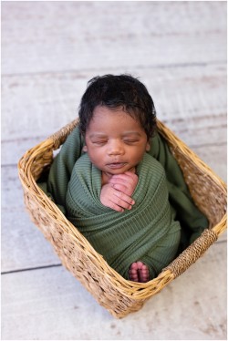 newborn boy in olive green swaddle