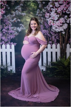 studio maternity portrait with floral fence backdrop