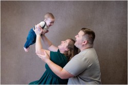 parents flying baby in air